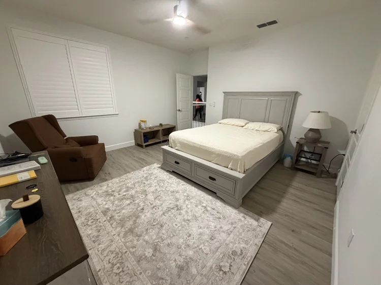 An upstairs bedroom with a storage bed frame and a reading chair.