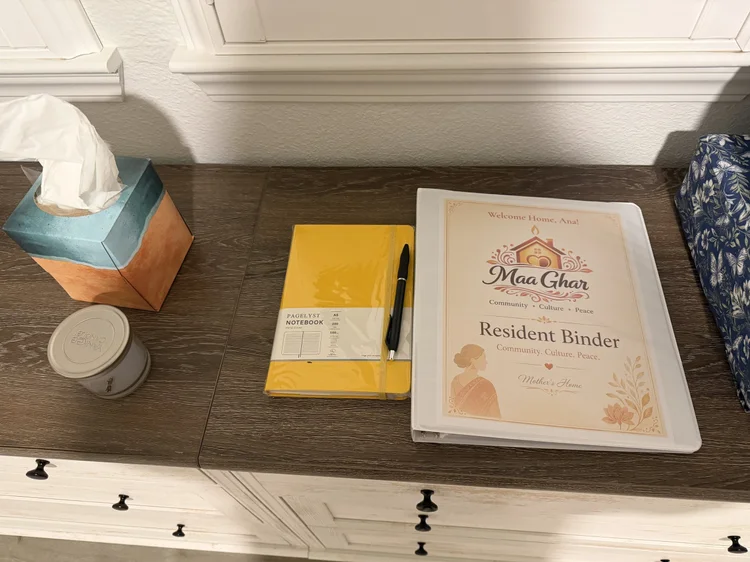The Maa Ghar resident binder, left out on a bedroom dresser.