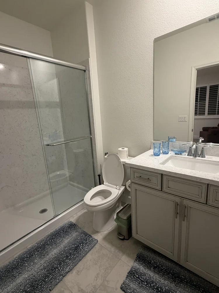 A full bathroom with a glass shower enclosure.