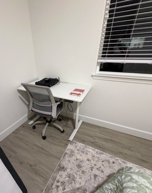 A desk and chair by the window in a private bedroom.