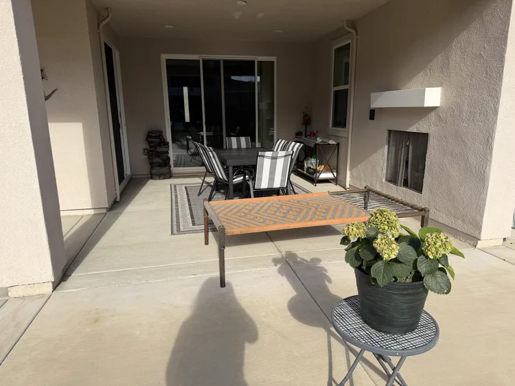 The covered patio, with an outdoor table and a bench.
