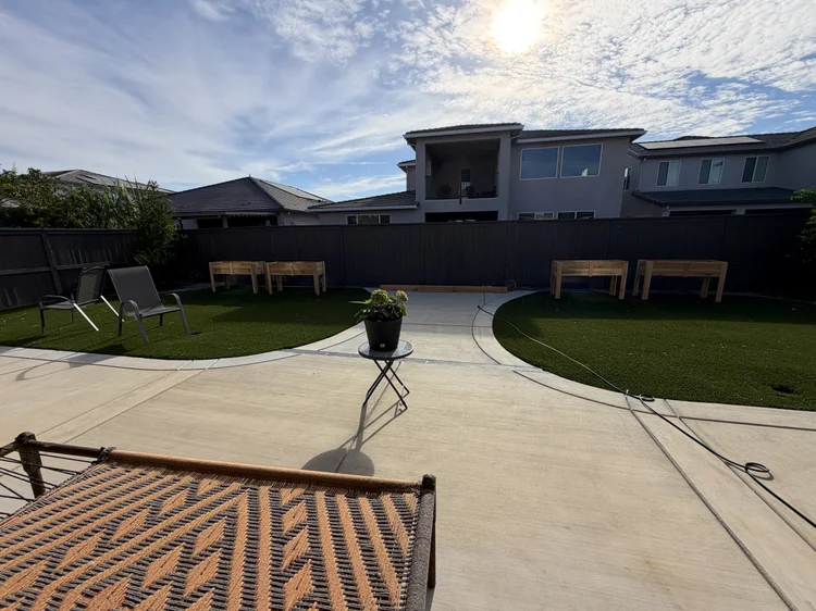 The backyard seen from the patio, with a hammock in the foreground.