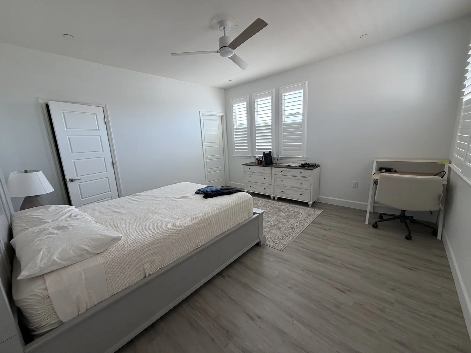 The Attached Bathroom Bedroom at Maa Ghar, with a desk, a dresser and shuttered windows.